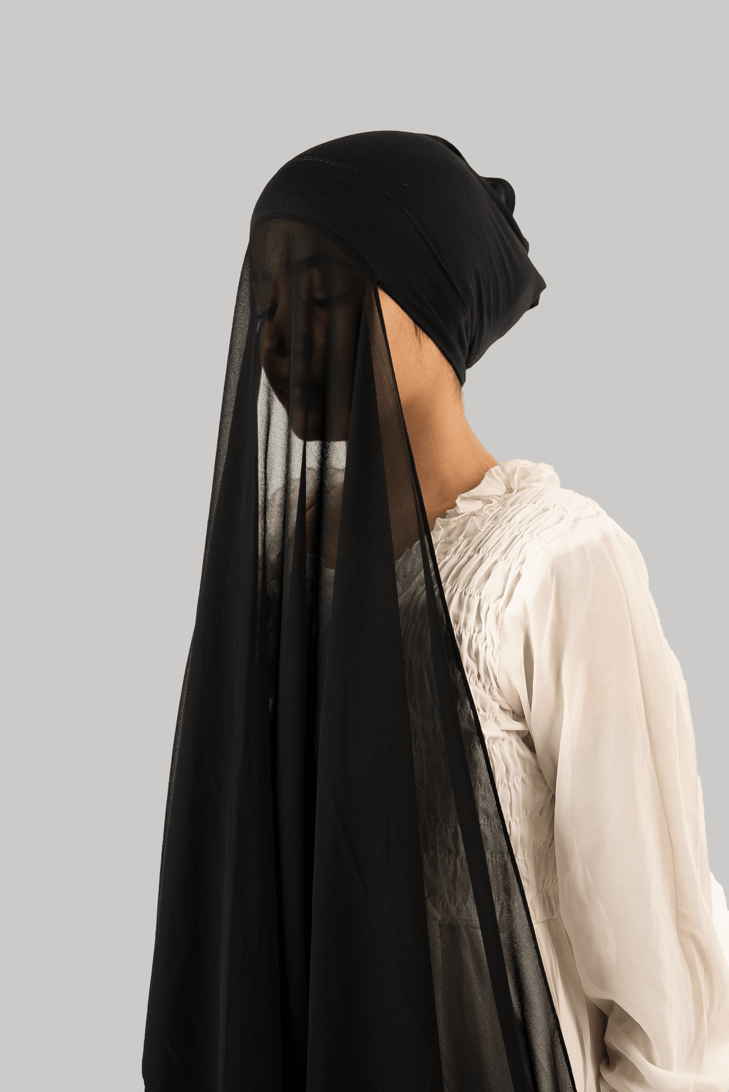 girl wearing georgette instant hijab with attached inner cap/ tube cap in black color side profile.