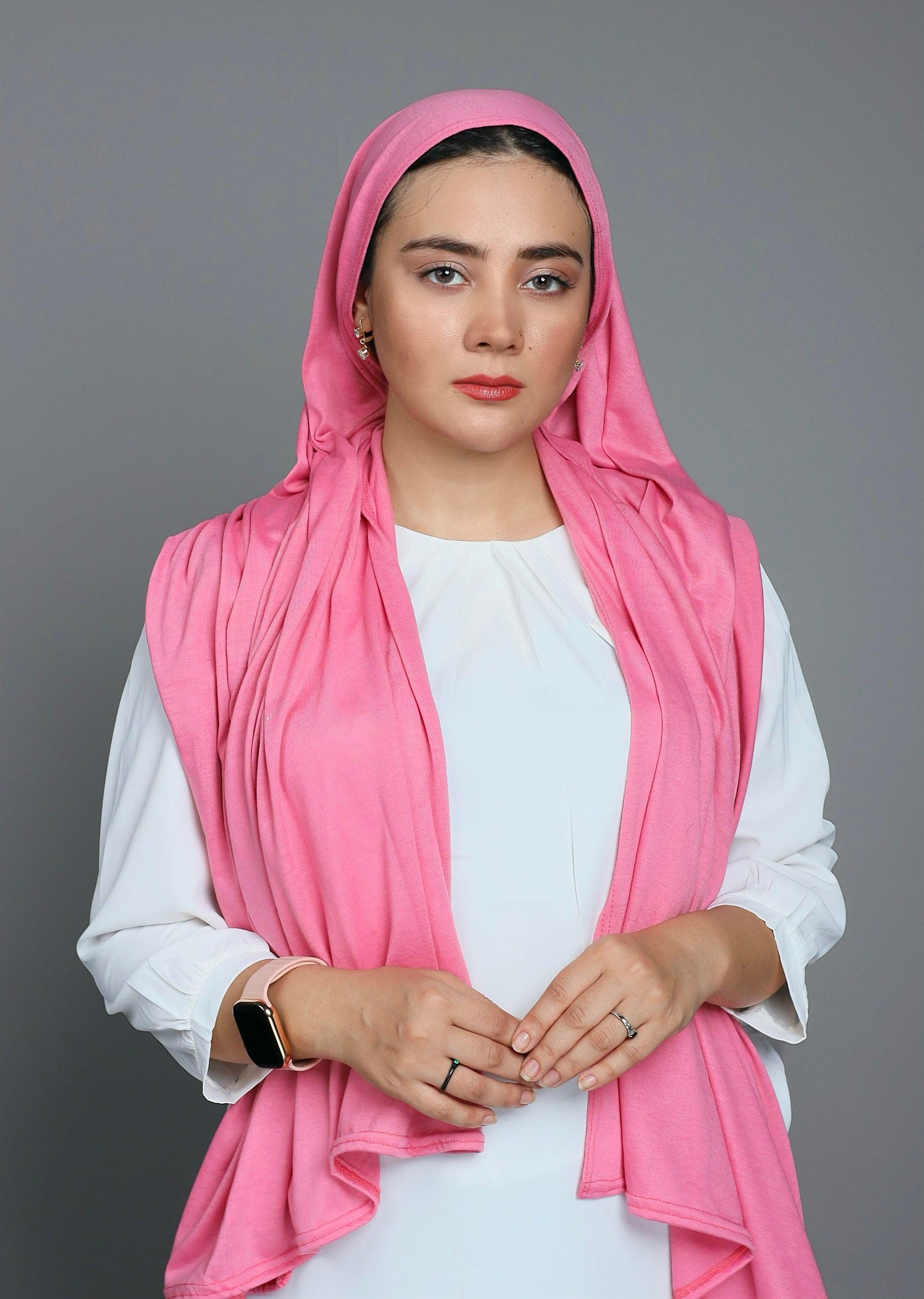 Woman wears jersey fabric scarf. Hijab in blossom shade. Looking her front.