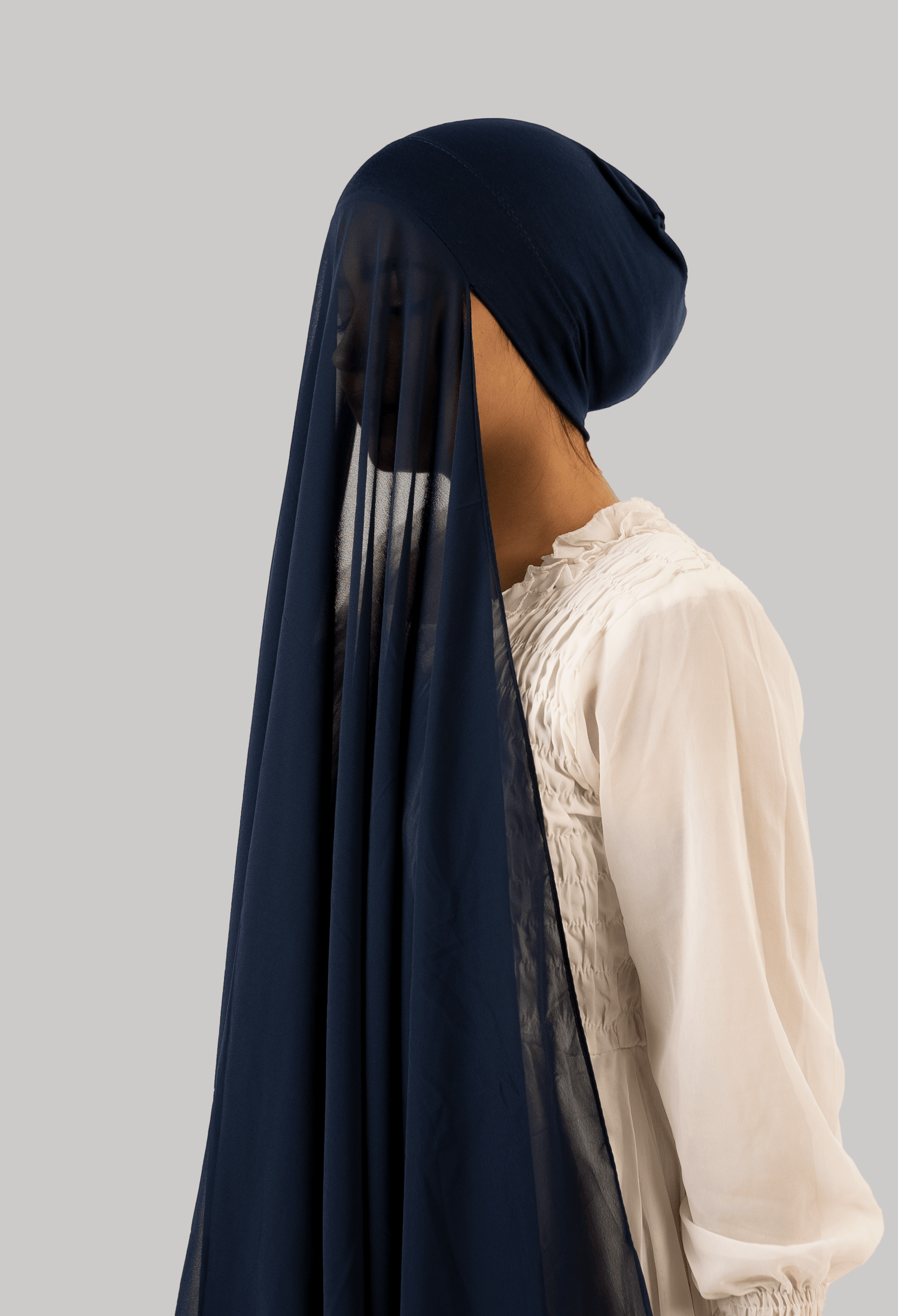 Girl wearing georgette instant hijab with attached undercap/ tube cap in navy blue. side profile