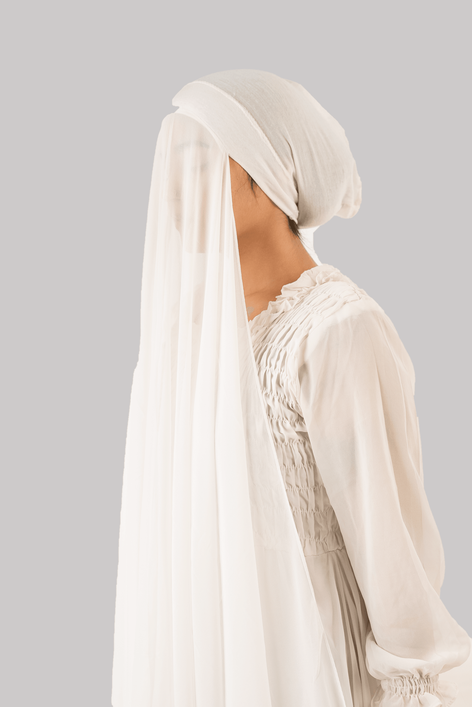 a women wearing instant hijab with cap in white color georgette material side profile