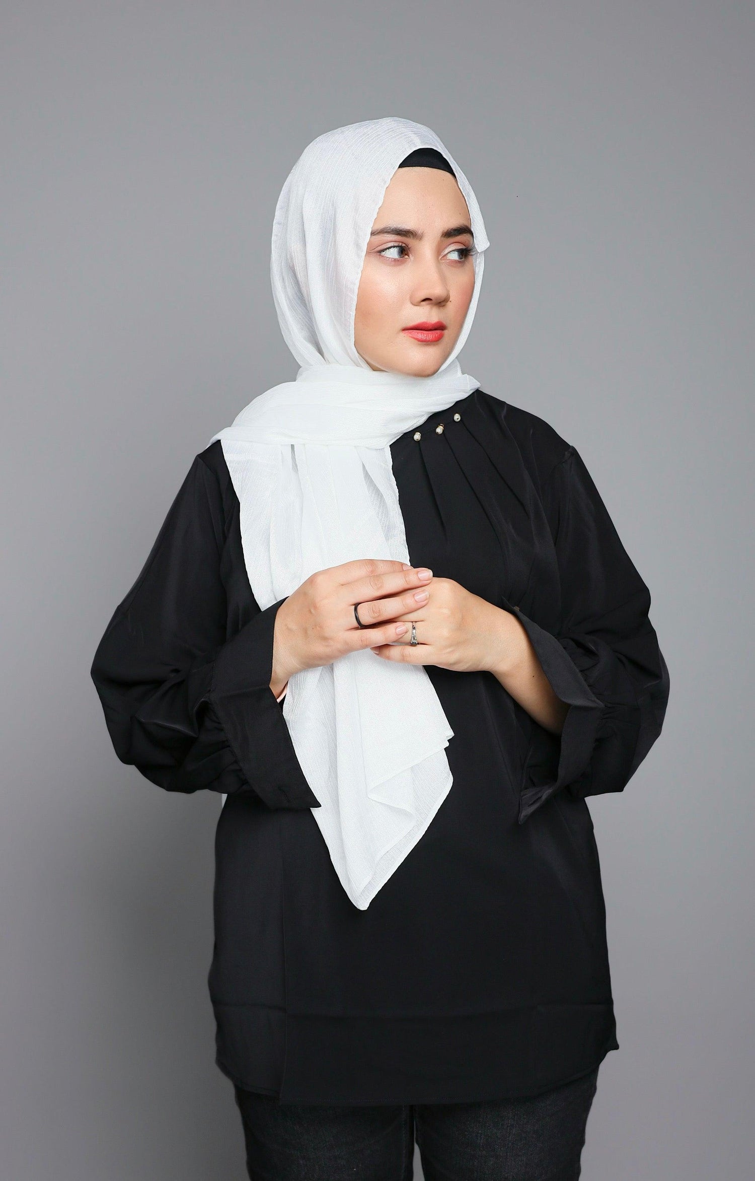 Modern Hijabi wearing pure white chiffon hijab over elegant black top.