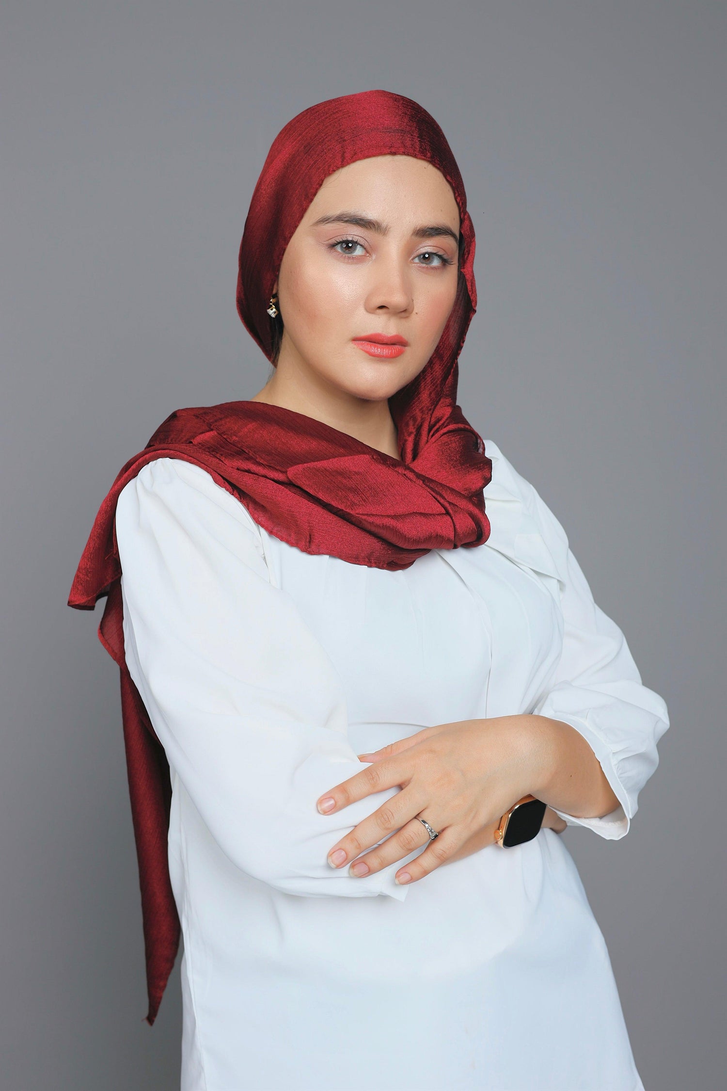 Woman draping in Metallic Chiffon Hijab in Maroon over white top.