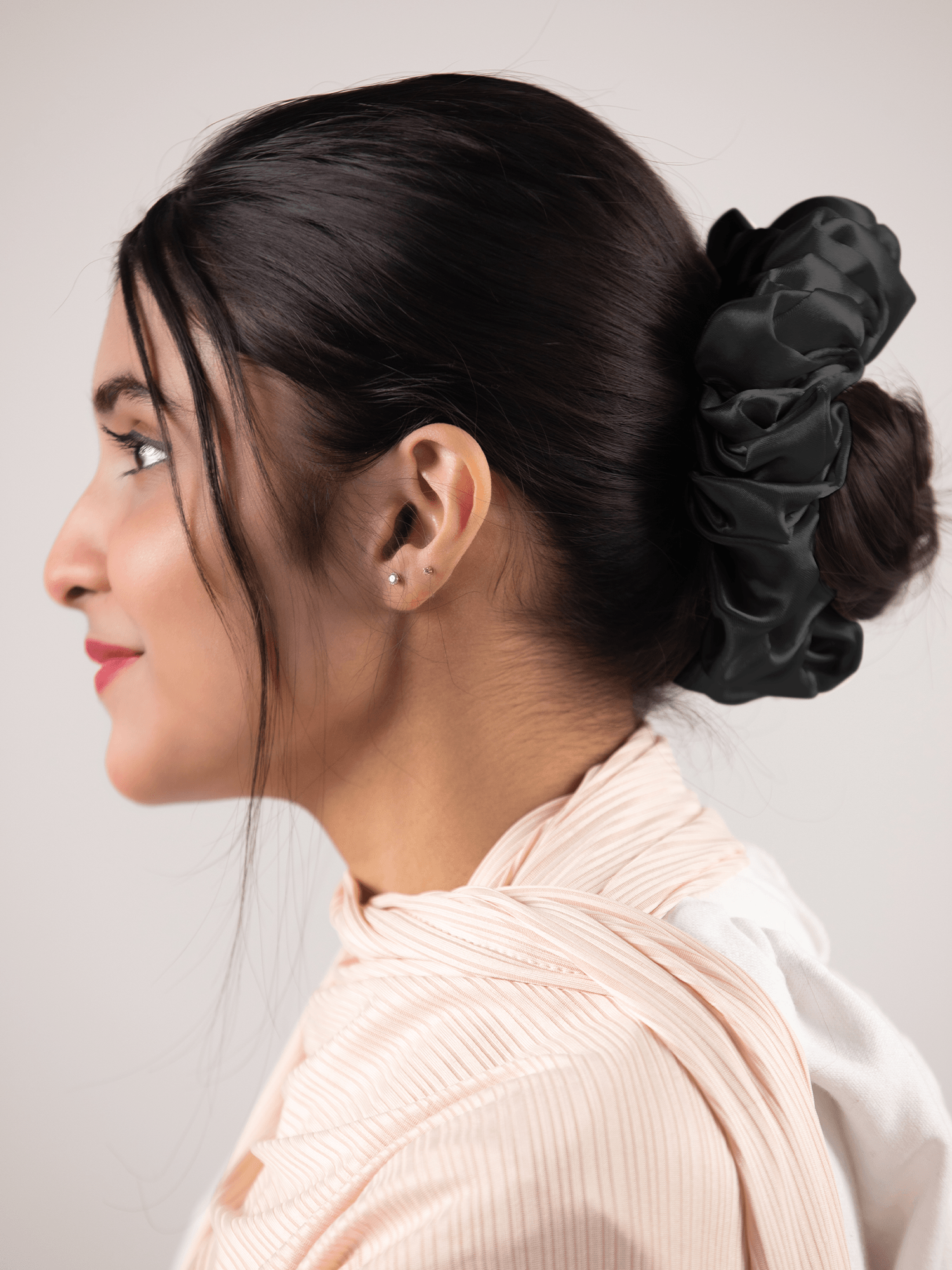A girl wearing volumizer for hijab hair accessorie silk fabric in black color.