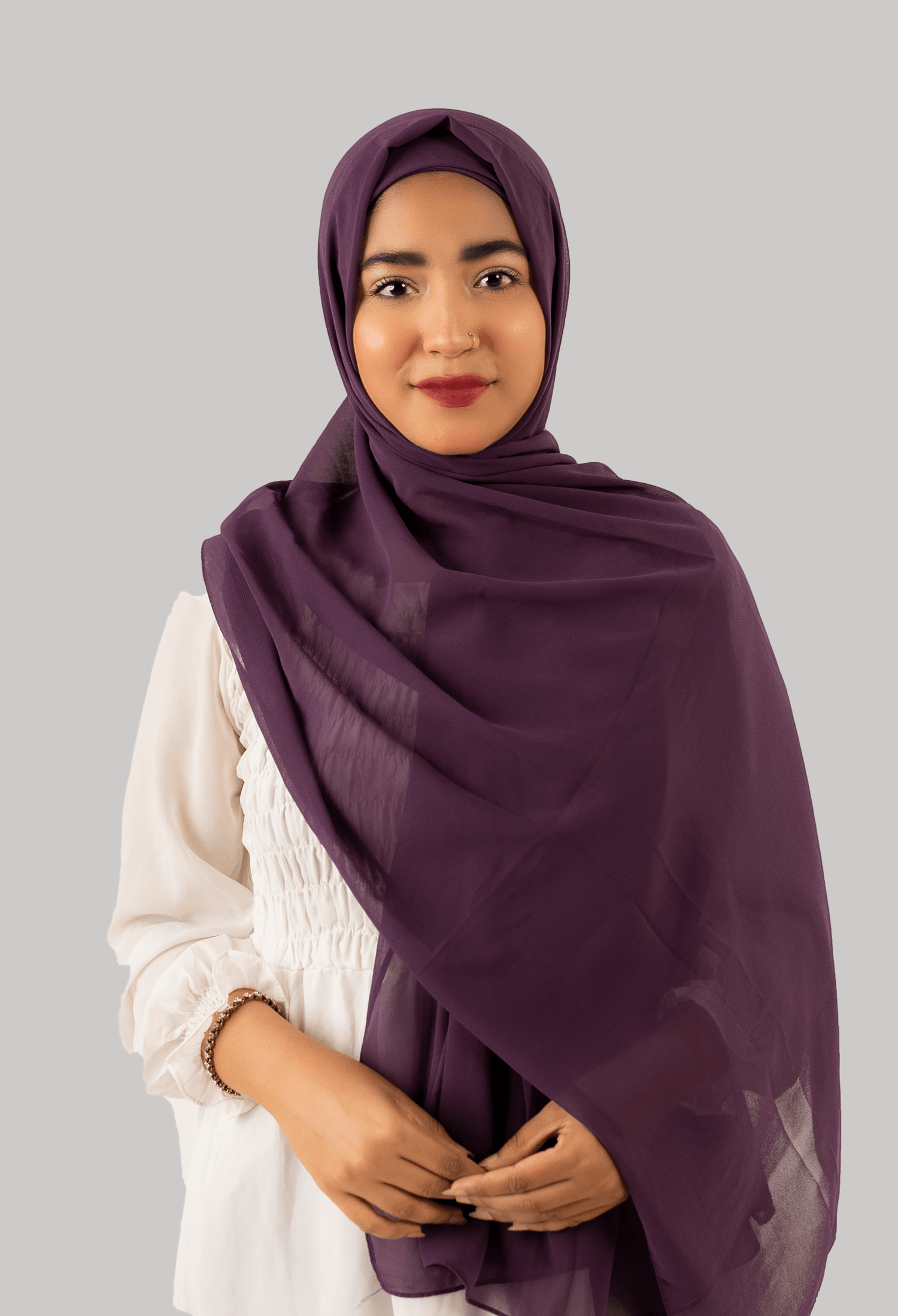 A luxurious purple instant hijab with cap adorns a woman, made from high-quality georgette.