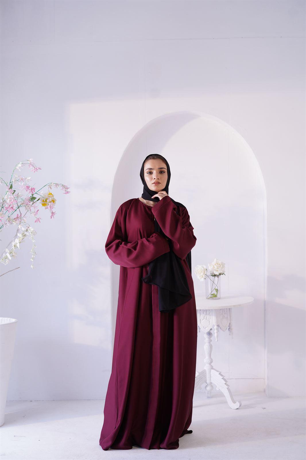 Luxury Abaya Online. Woman Wearing Amirah Abaya In maroon color. Front view.
