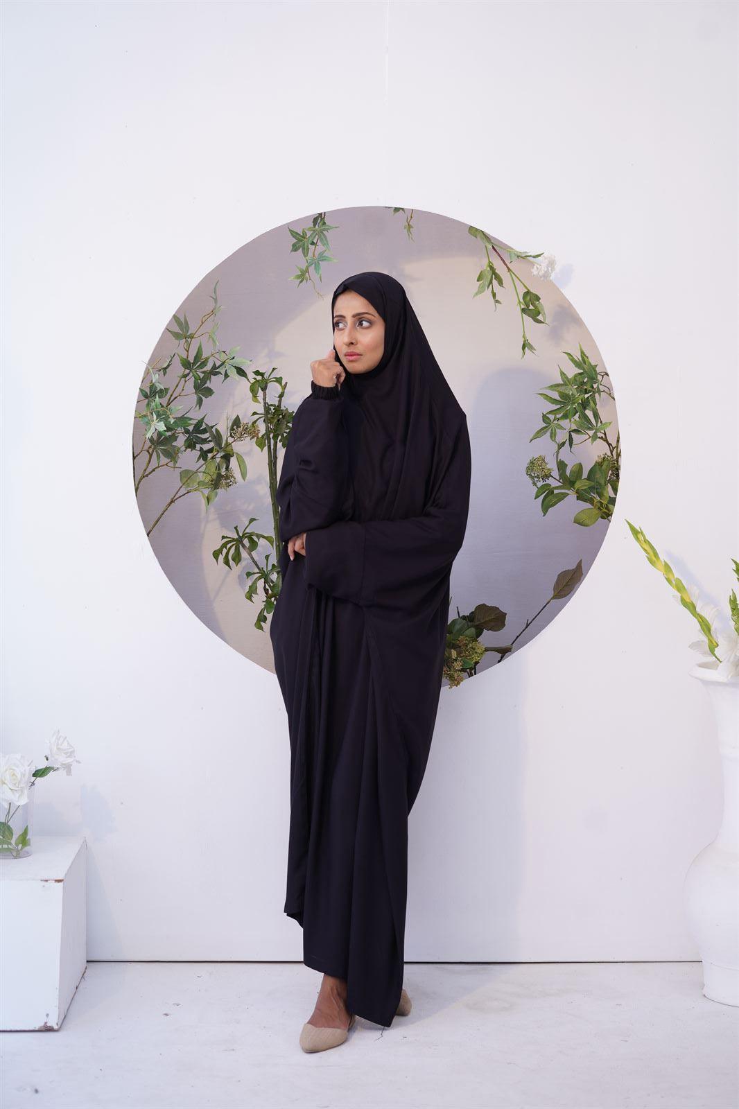 A girl wear namaz chadar with sleeves in black color