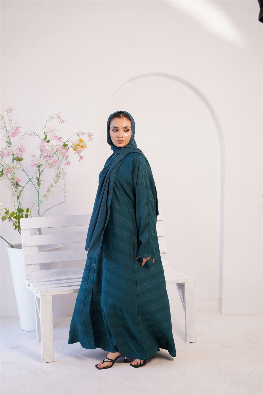 Girl wearing Nida Fabric Zoom Emboss Gown Style Abaya in Pine Green side view.