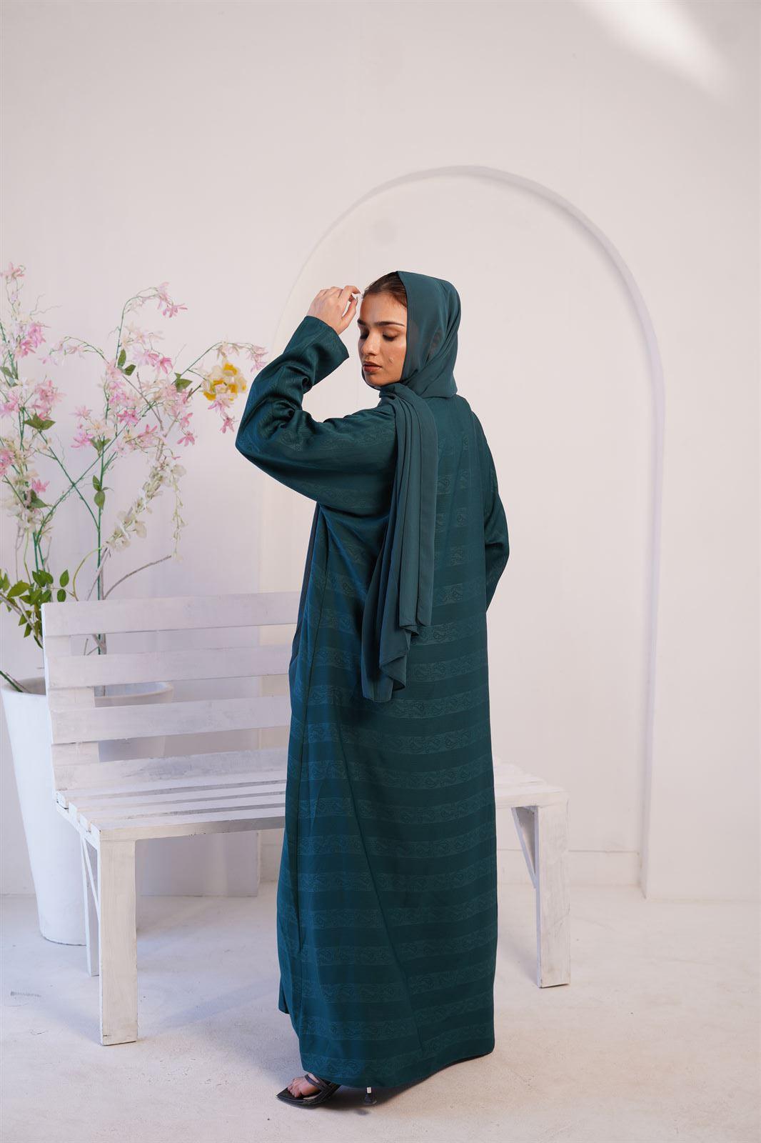 Woman wearing premium Zoom Embossed Gown Style Abaya in Pine Green. Back view.