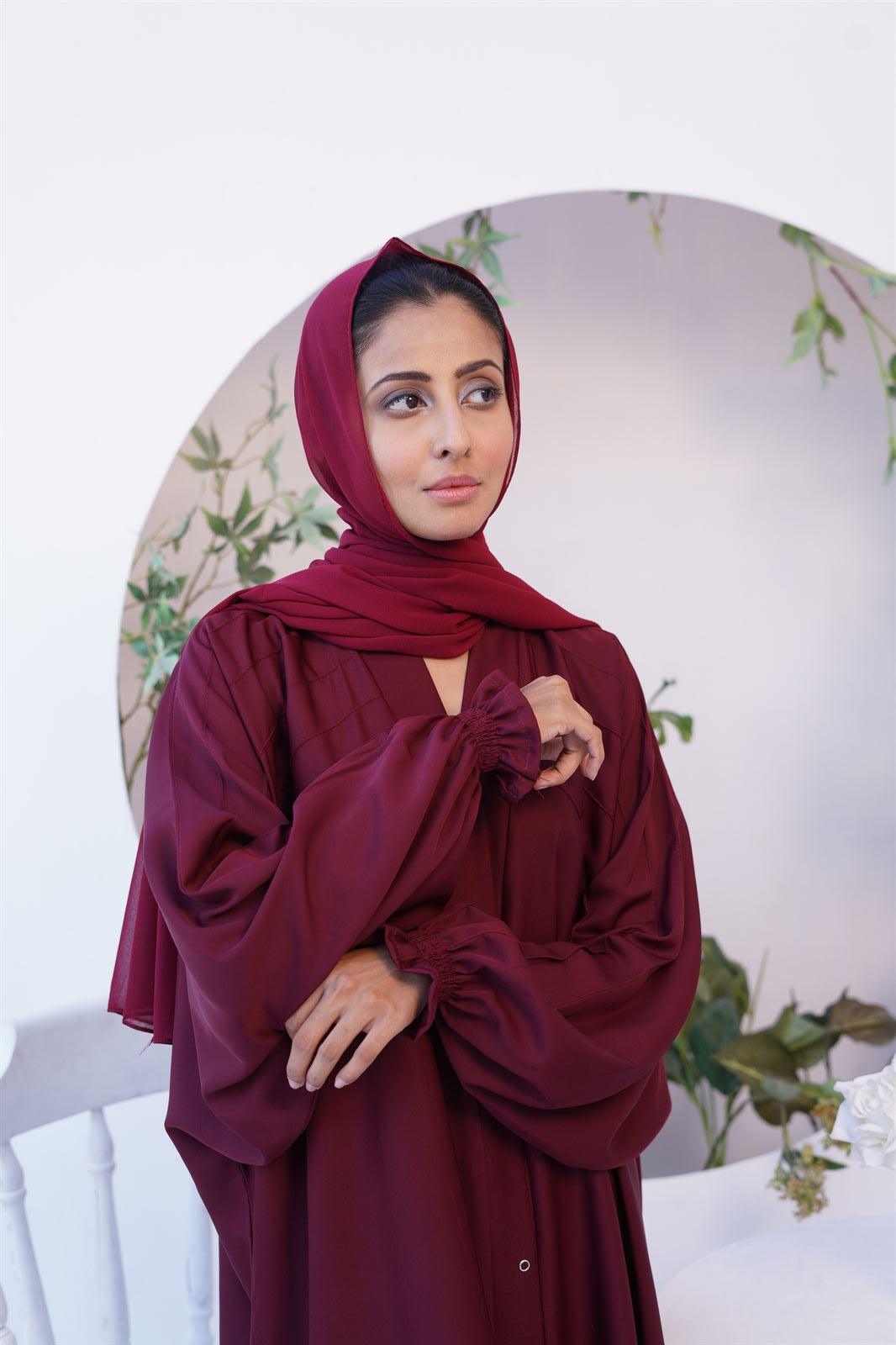 Girl wearing kaftan gown abaya in maroon.