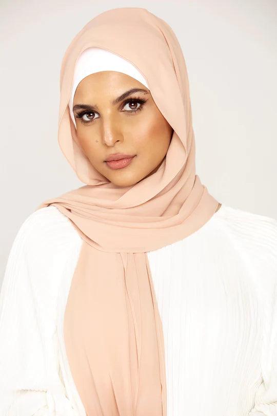 Georgette Hijab Online Pakistan, in nude color. A woman wearing it with white top looking her straight.