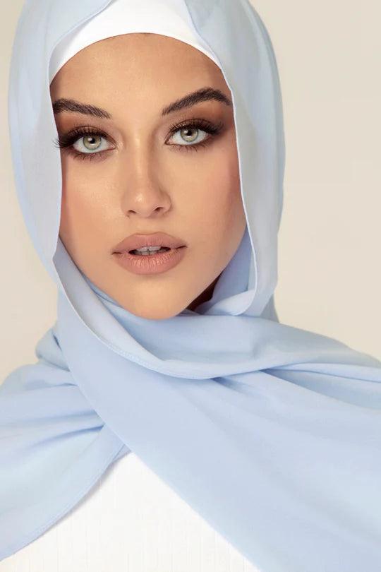 Georgette Hijab Online Pakistan, in baby blue color . a women wearing it with white top looking her staight.