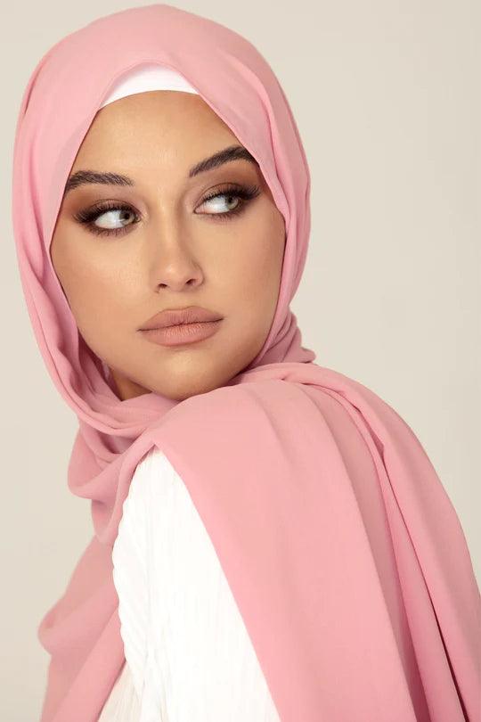 Georgette Hijab Online Pakistan, in nude pink color . a women wearing it with white top looking her left.