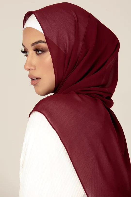 Woman wearing Premium Georgette Hijab in Maroon over white top.
