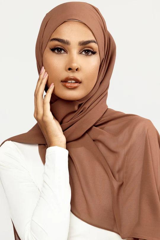 Georgette Hijab Online Pakistan, in dark mocha color . a women wearing it with white top looking her straight
