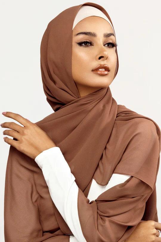Georgette Hijab Online Pakistan, in dark mocha color . a woman wearing it with white top looking her straight
