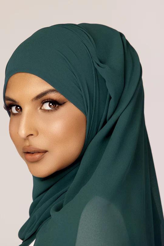 Georgette Hijab Online Pakistan, in Teal color. Side profile of a woman wearing it with white top looking her left.