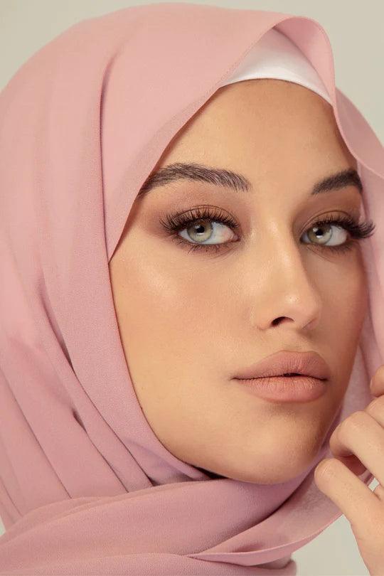 A women wearing Dusty Pink Georgette Hijab with white top looking to her straight