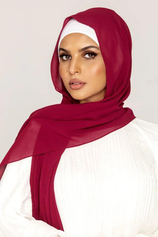 Georgette Hijab Online Pakistan, in cherry color . a women wearing it with white top looking her straight.