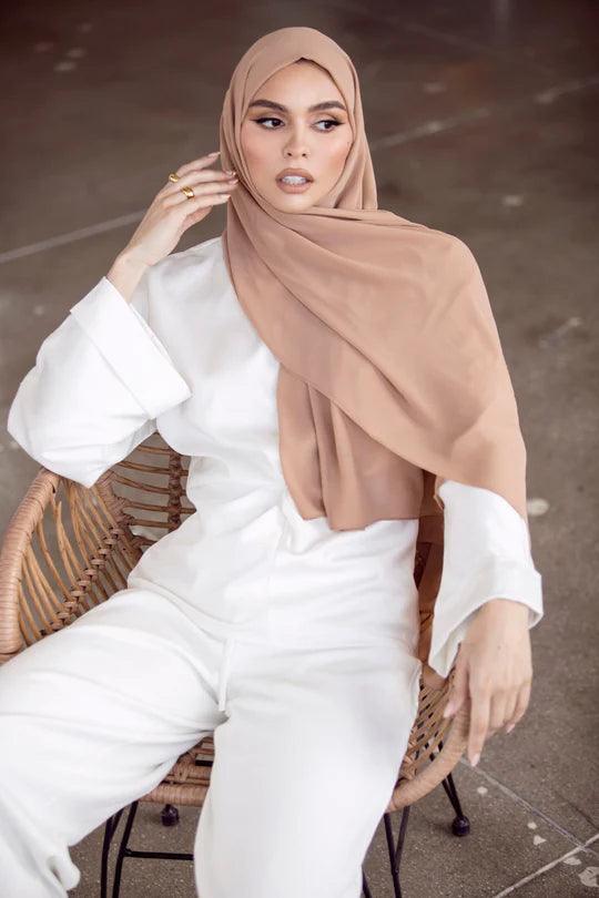 Georgette Hijab, in beige. Girl wearing over white top looking her left.