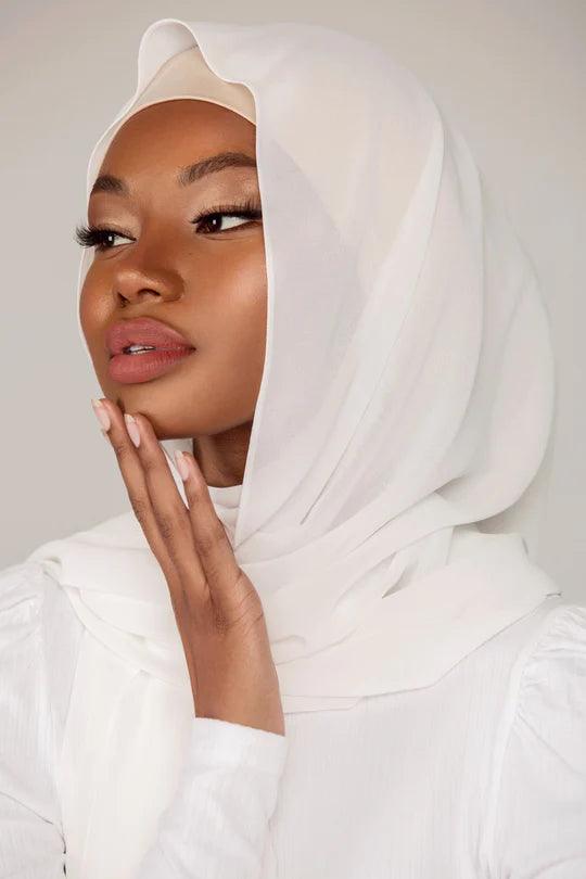Plain White Georgette Hijab, girl wearing it over a white top, looking her right.