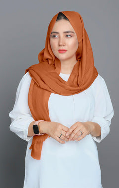 Woman wearing an Apricot colored Turkish Hijab, showcasing a stylish and elegant look. Versatile & Chic Hijabs made from Premium Cotton Viscose Fabric.