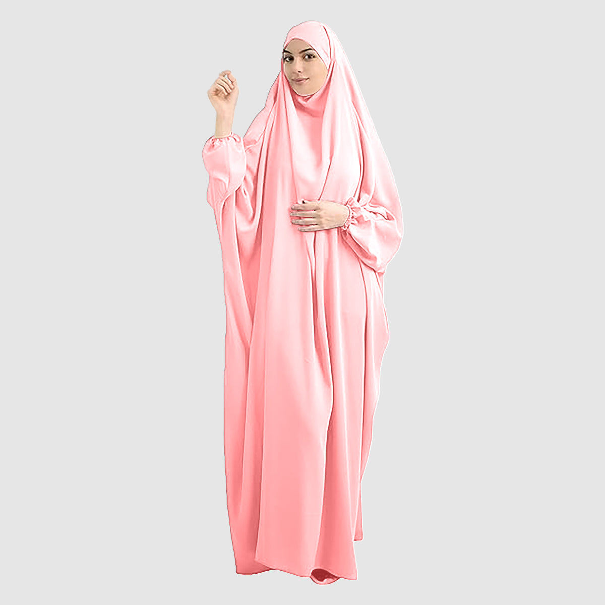 A woman wearing a pure Namaz Chadar in baby pink color is looking straight.