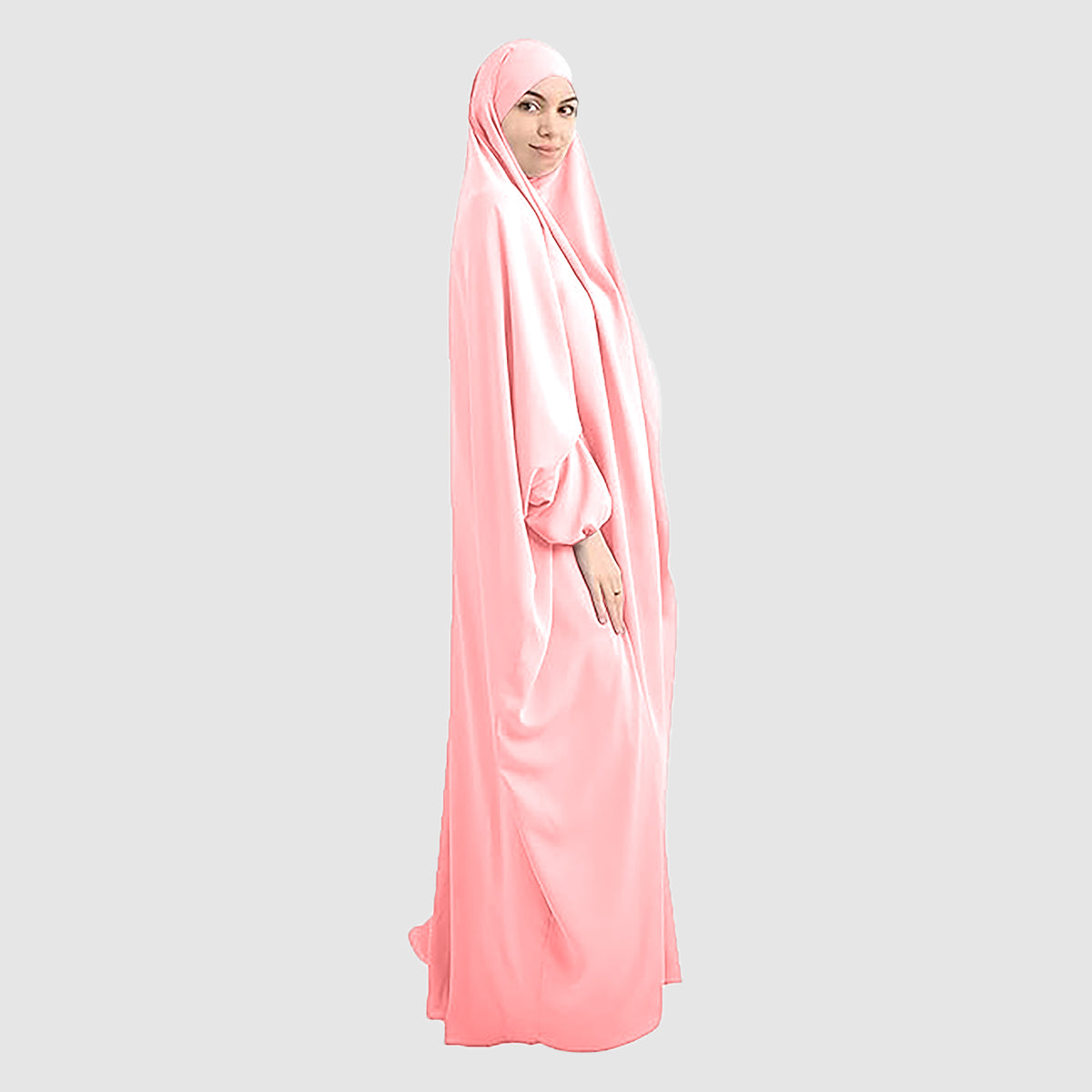 A woman wearing a pure Namaz Chadar in baby pink is looking straight side profile.