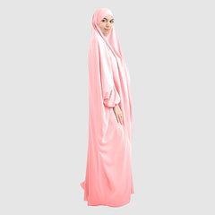 A woman wearing a pure Namaz Chadar in baby pink is looking straight side profile.