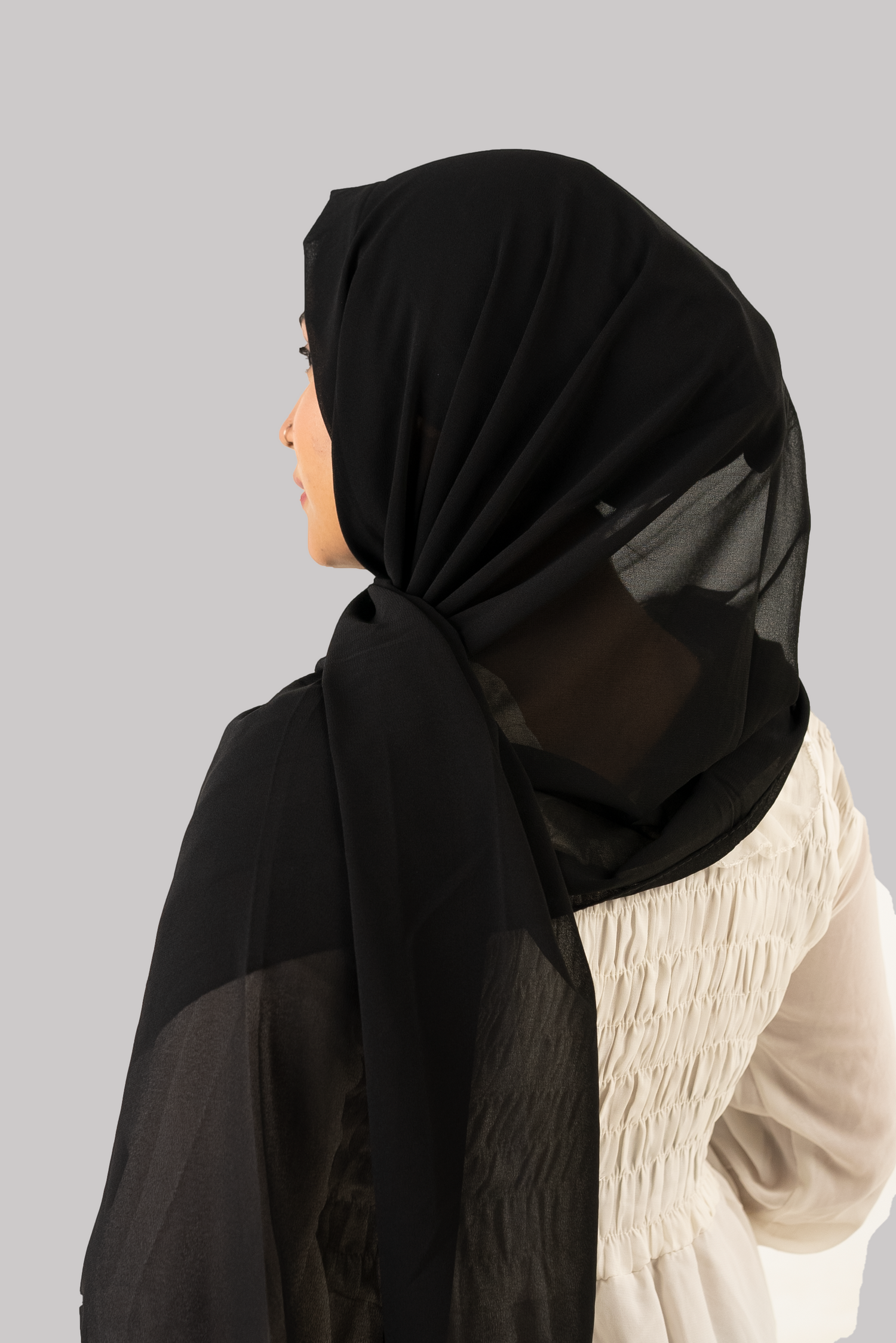 a women wearing instant hijab with cap in black color georgette material back side