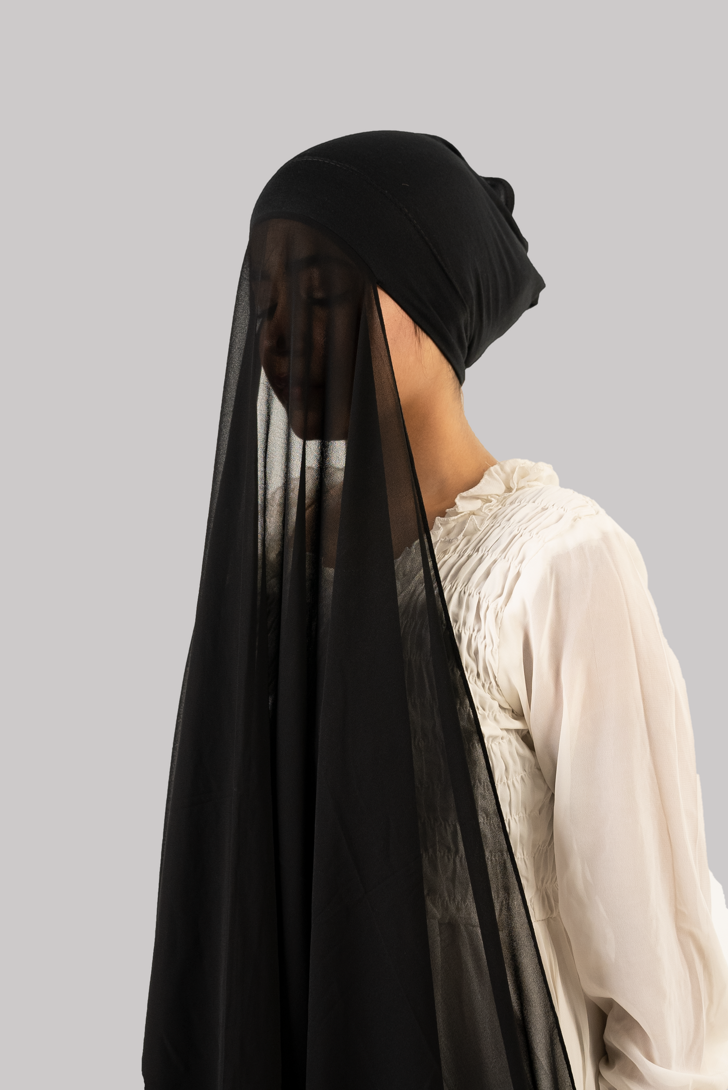 a woman wearing instant hijab with cap in black color georgette material side profile, black color