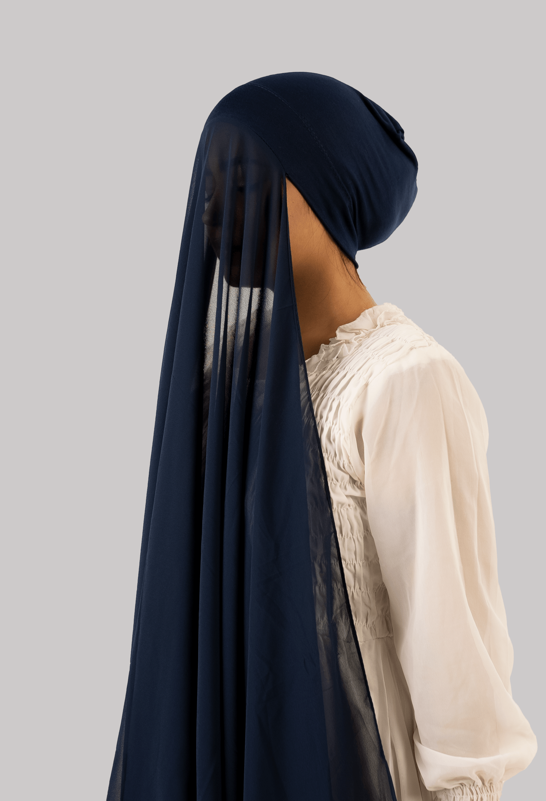 Girl wearing georgette instant hijab with attached undercap/ tube cap in navy blue. side profile