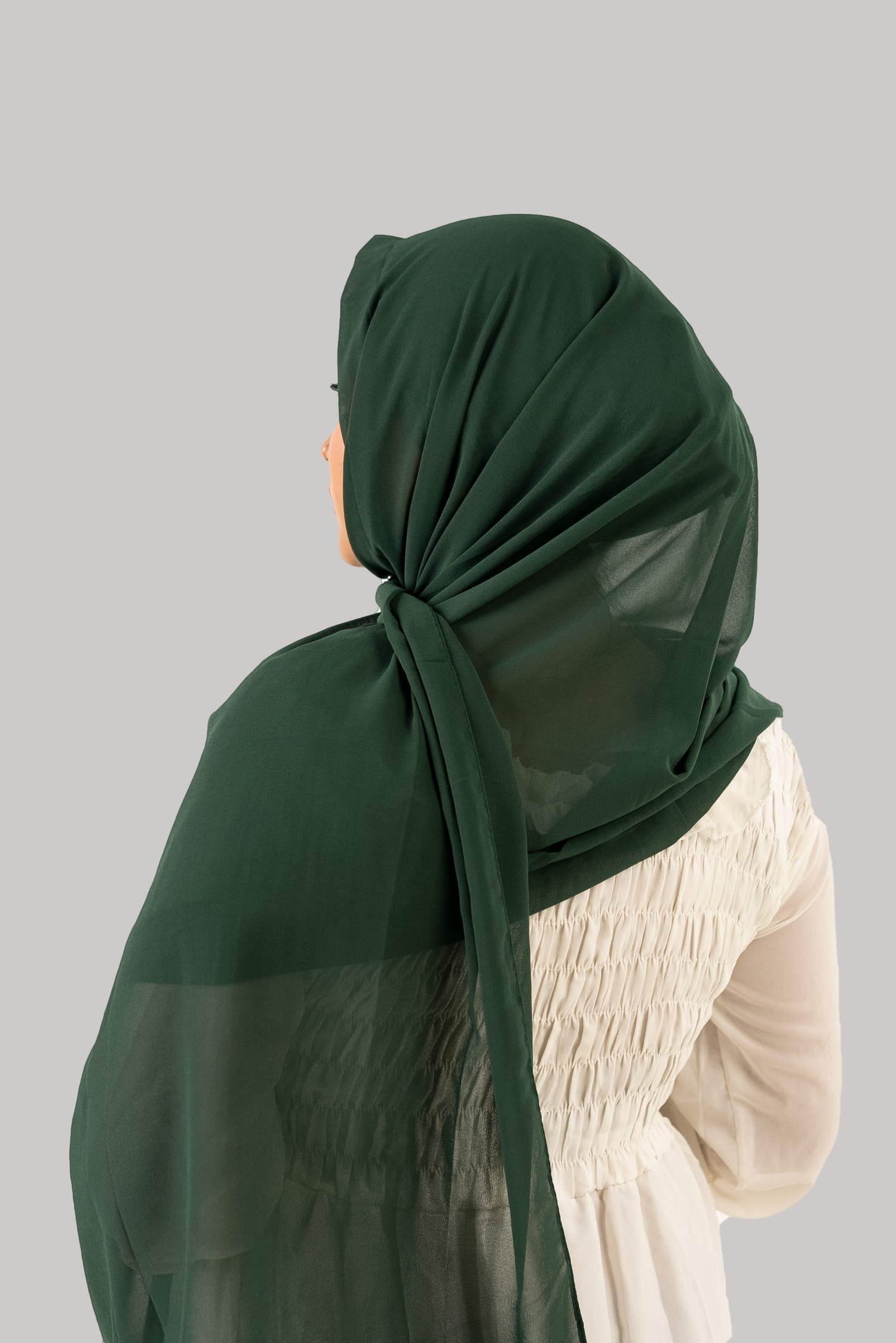 a women wearing instant hijab with cap in dark green color georgette material back side