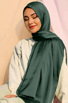 Stylish Woman wearing Satin Silk Hijab in dark green color.