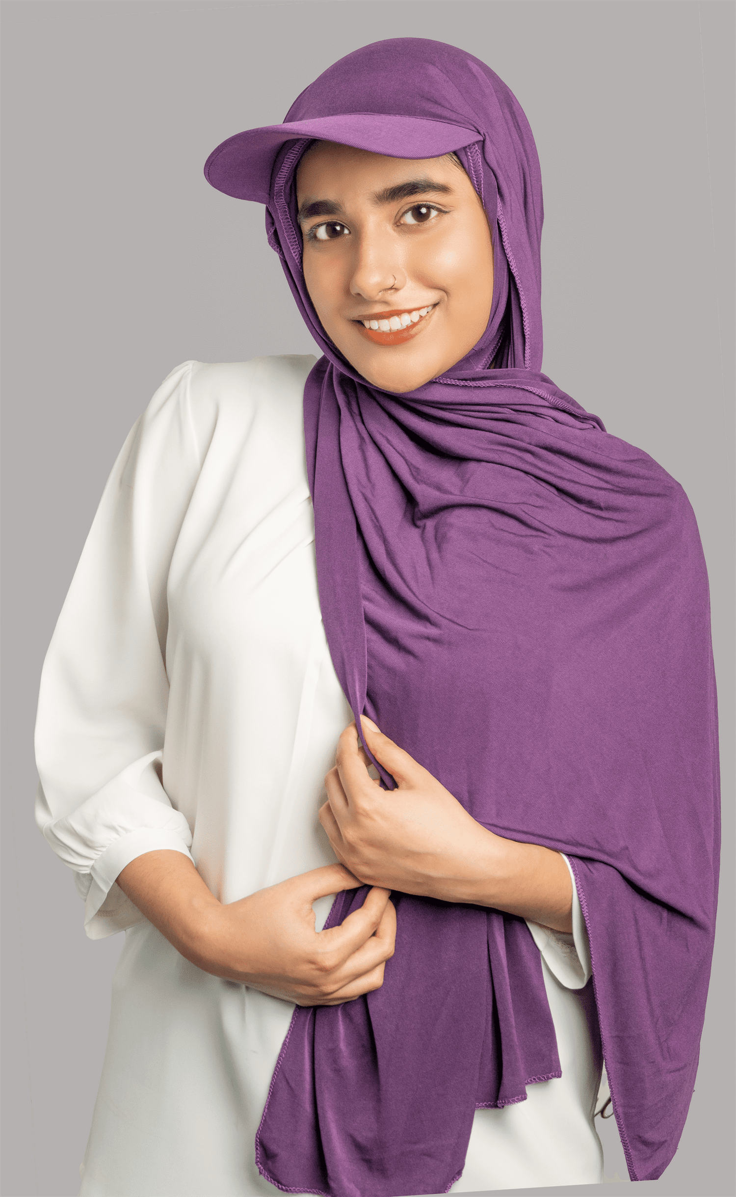 Woman wearing Hat Hijab in purple over a white top.