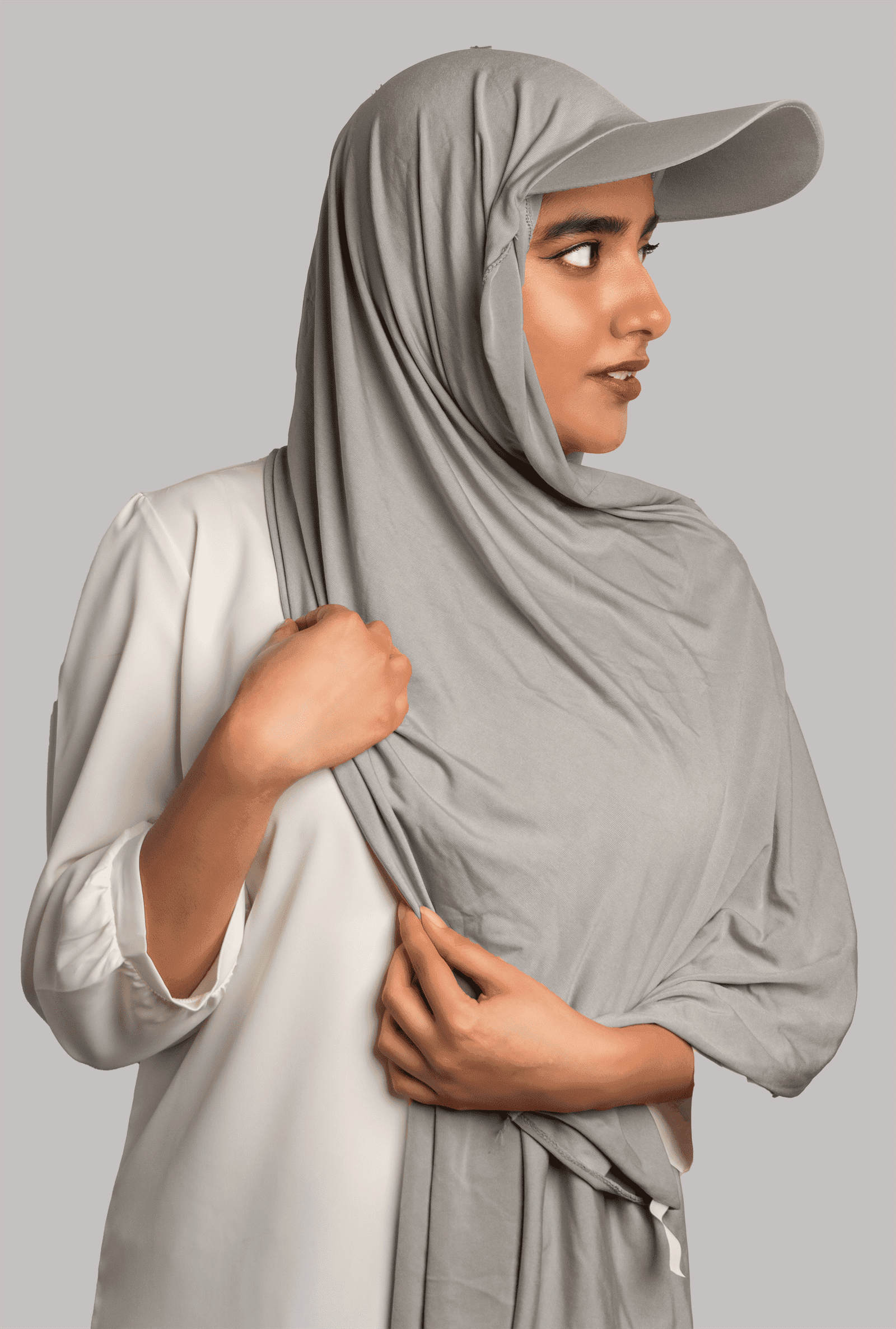 Girl Wearing Stylish Hat Hijab in grey color. looking left.