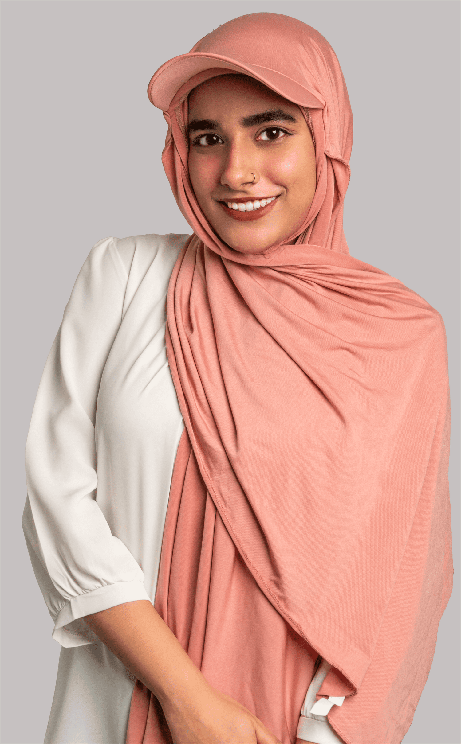 A women wearing a stylish Hat Hijab in pink color and a white top.