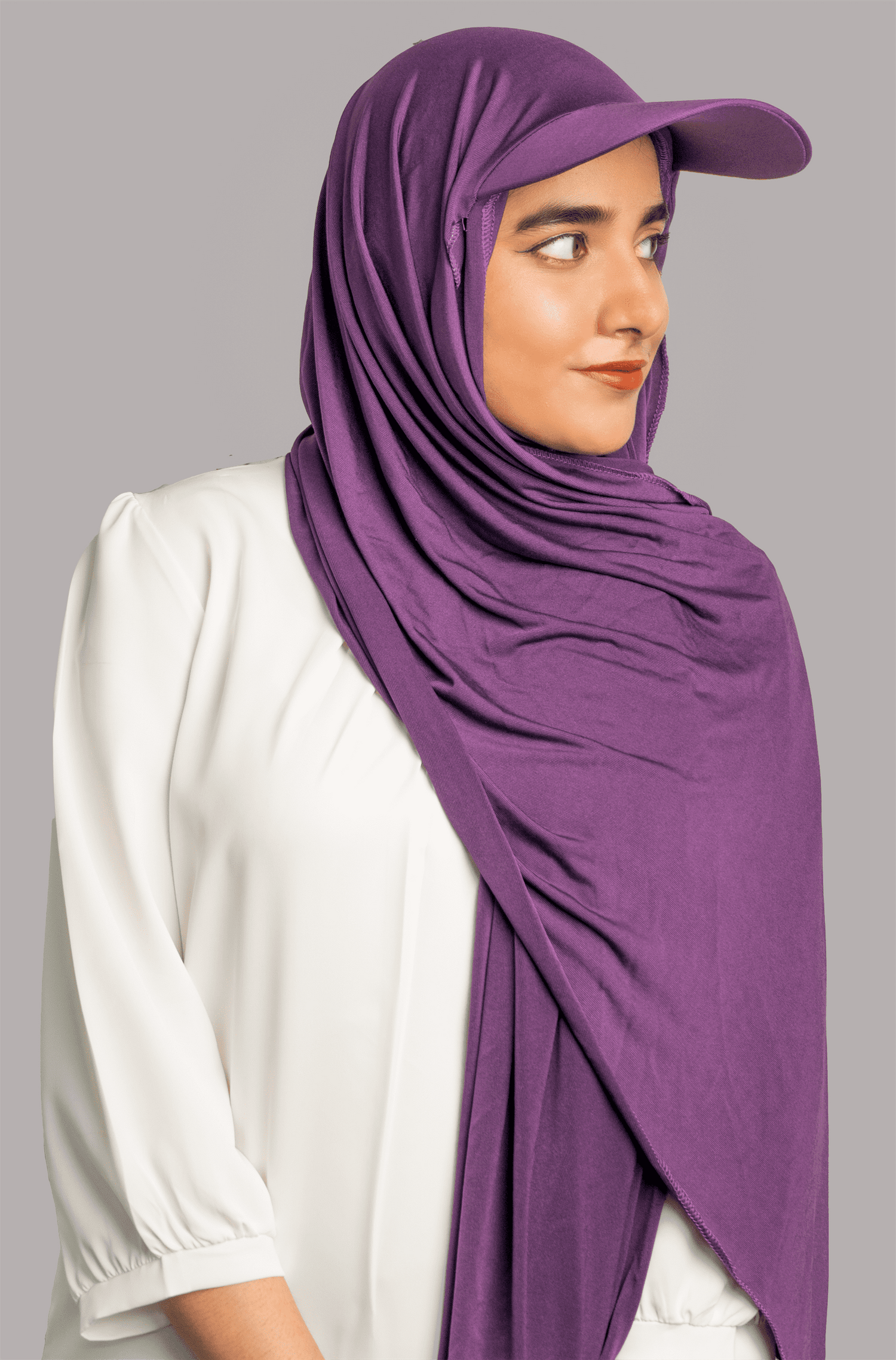 A women wearing a stylish Hat Hijab in purple color looking to her left.