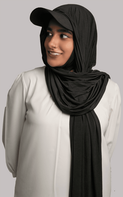 A women wearing a stylish Hat Hijab in black color and a white top looking to her right