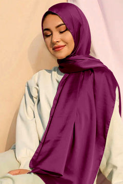 A woman elegantly wearing a luxurious Hot Pink Satin Silk Hijab.