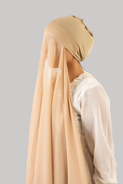 a women wearing instant hijab with cap in beige color georgette material side profile