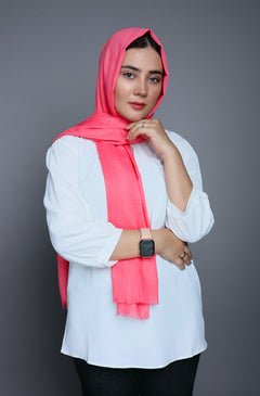 A woman wearing a soft Peach Quartz Turkish Hijab, showcasing a stylish look and radiant smile. Made from Comfortable breathable cotton viscose fabric.