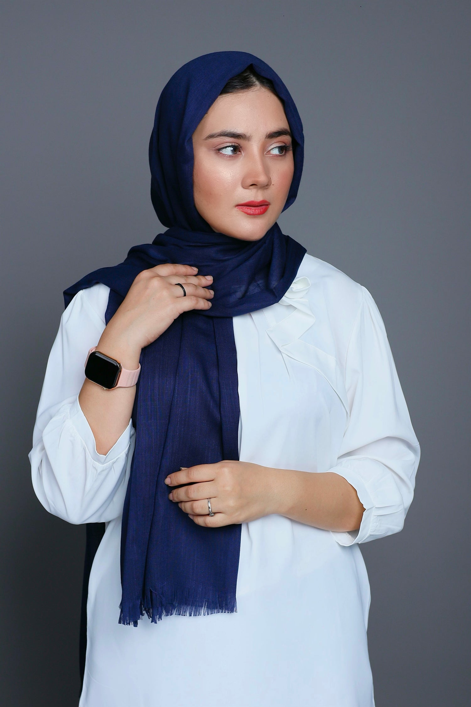 Girl wearing Turkish Hijab, viscose fabric, in Black color, with white top looking her left.