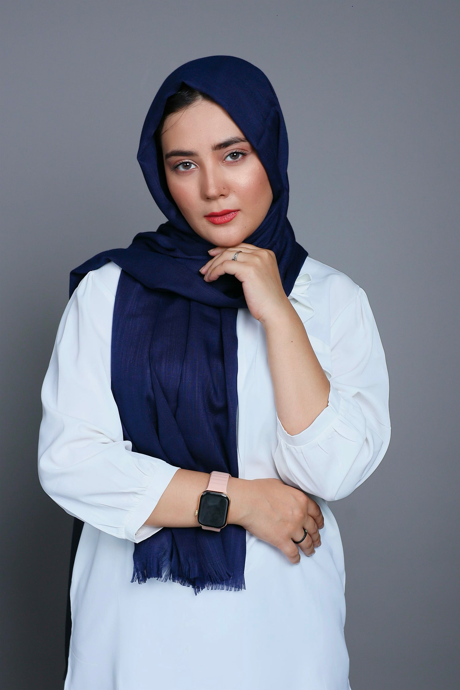 A women wearing Turkish Hijab, viscose fabric, navy blue color, with white top looking her straight