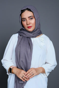 Woman styling a warm charcoal Hijab, highlighting its non-slip feature for all-day comfort.