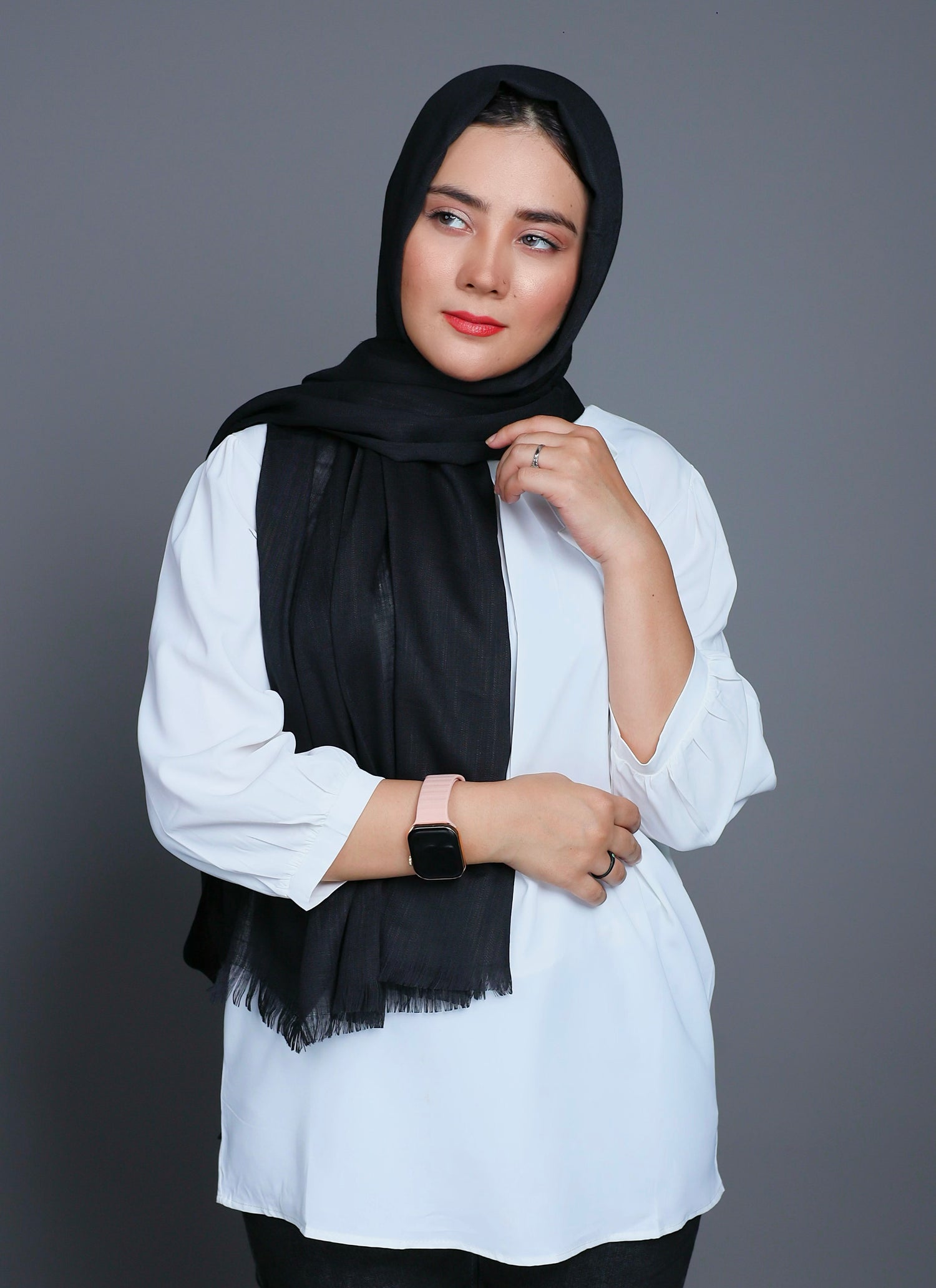 A women wearing Turkish Hijab, viscose fabric, in Black colour, with white top looking her right