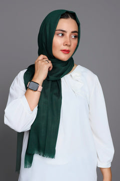 Girl wearing Turkish Hijab, viscose fabric, in bottle green, with white top looking her left.