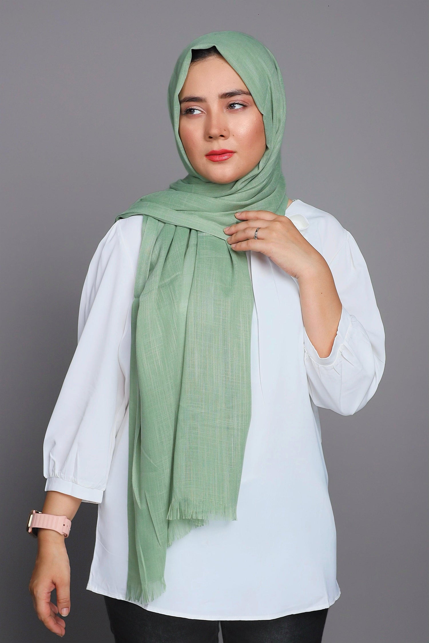 Turkish Scarf Hijab in Apple Green, laid flat to show its luxurious fabric and warm, muted shade.