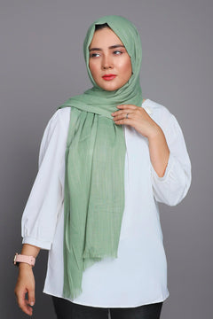 Turkish Scarf Hijab in Apple Green, laid flat to show its luxurious fabric and warm, muted shade.