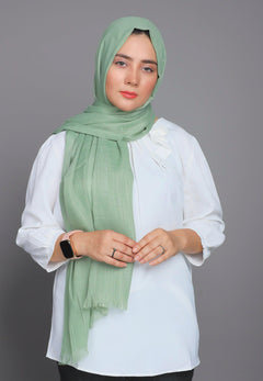 Woman Wearing Turkish Hijab in apple Green color, showing its light to medium thickness.