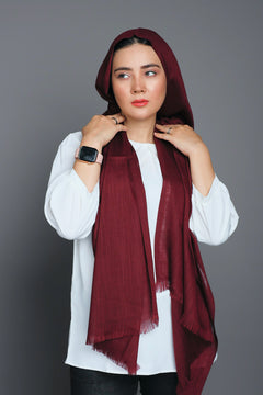 A women wearing Turkish Hijab, viscose fabric, in burgundy colour, with white top looking her right